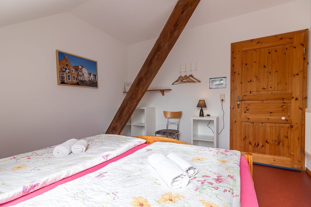 Doppelzimmer Greetsiel – Gästezimmer 5 Fernglas mit einem Doppelbett